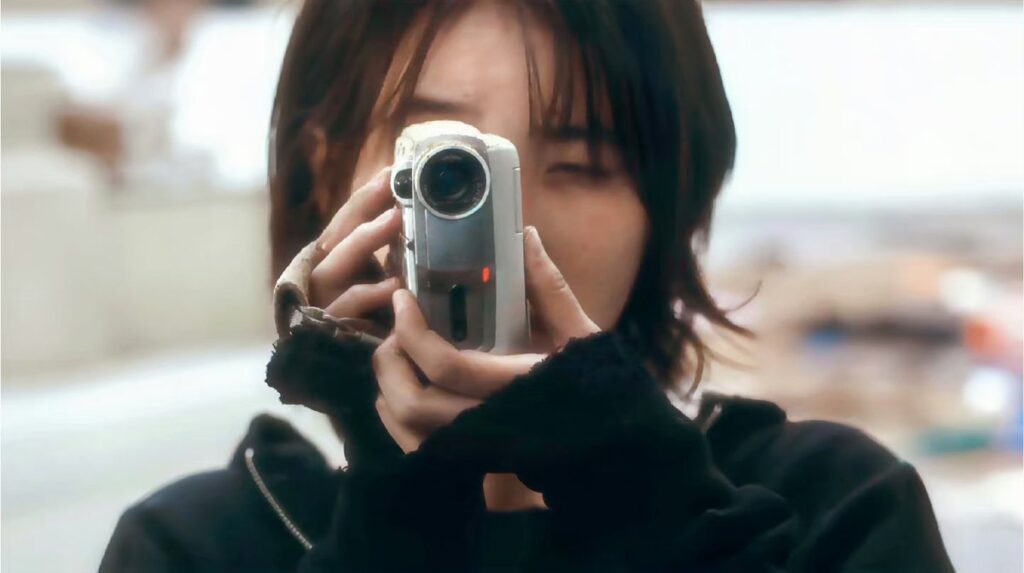 IU en una escena gris y postapocalíptica del video musical de Love wins all