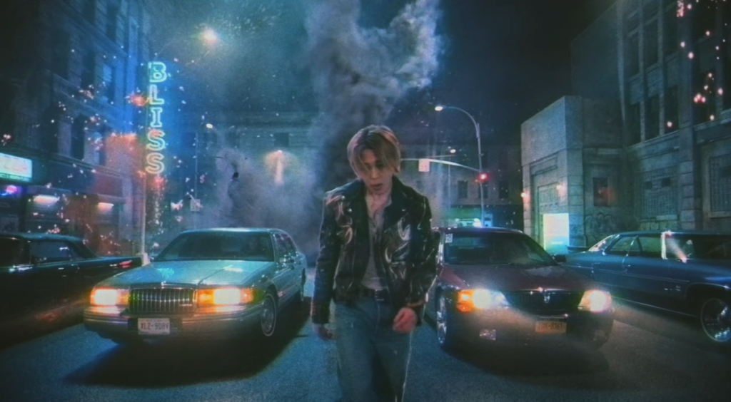 Jimin en el video musical de Who con una ciudad nocturna y luces de neón