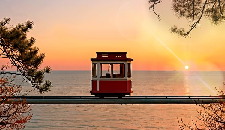 Beach Train avanzando por la costa de Busan al atardecer