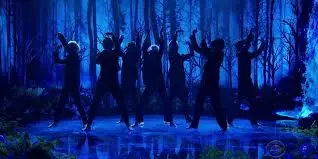 BTS en un escenario oscuro durante una presentación de Black Swan