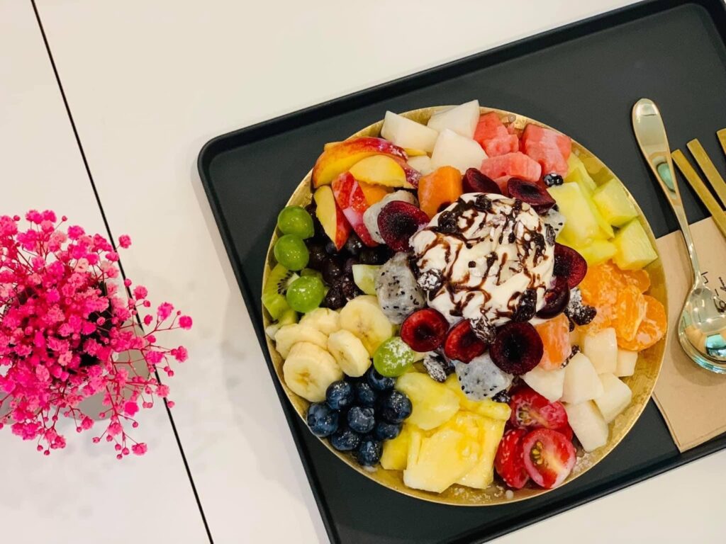Un bol de bingsu de fruta con fresas o mango por encima