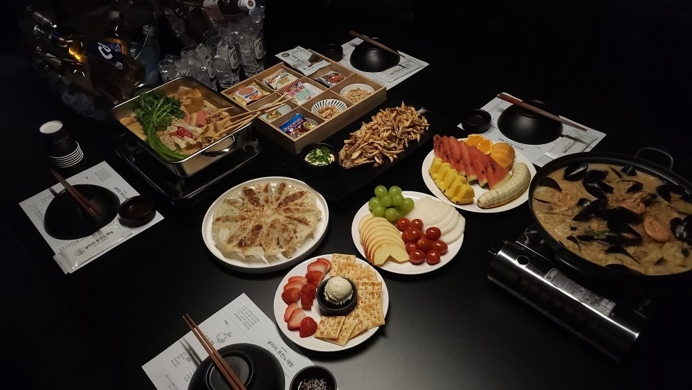 Grupo de amigos en una sala de noraebang coreano con bebidas y mesa