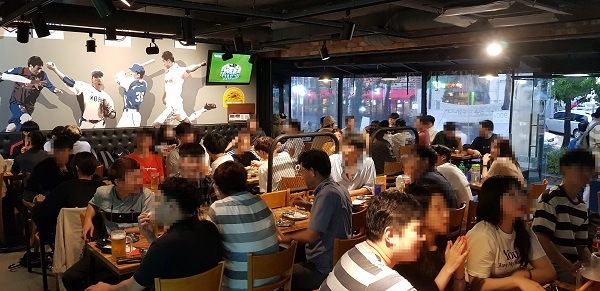 Personas compartiendo pollo frito coreano en una mesa de restaurante informal