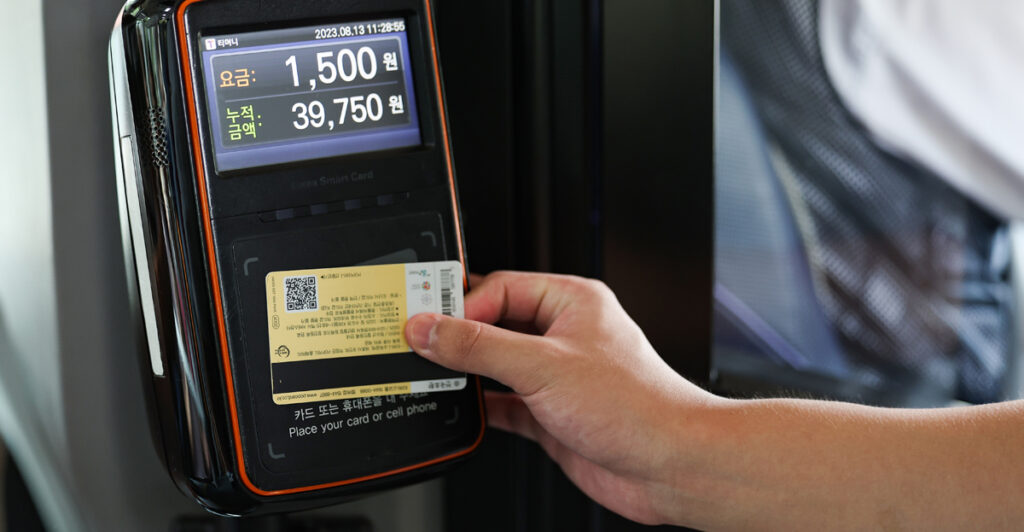 Pasajero usando una tarjeta de transporte en el lector de un autobús coreano