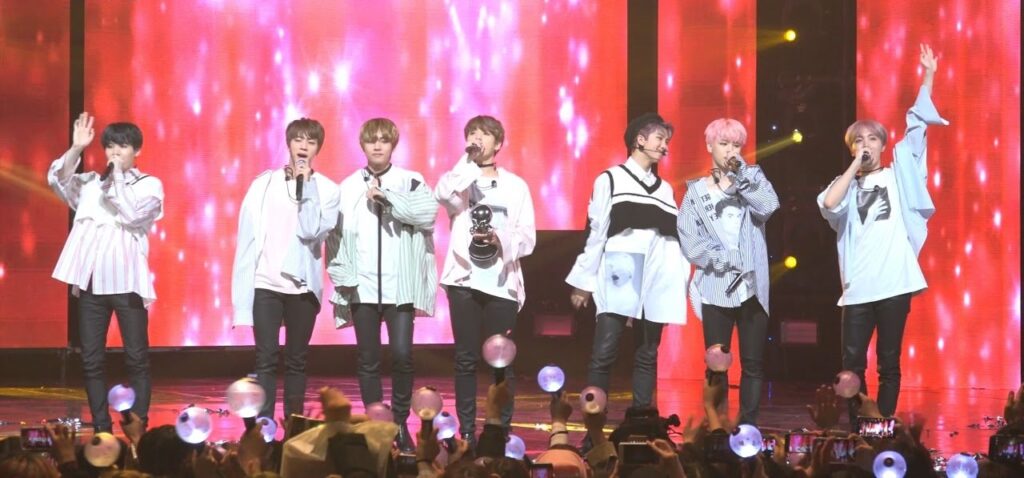 BTS performing Spring Day on stage with a soft winter-like atmosphere.
