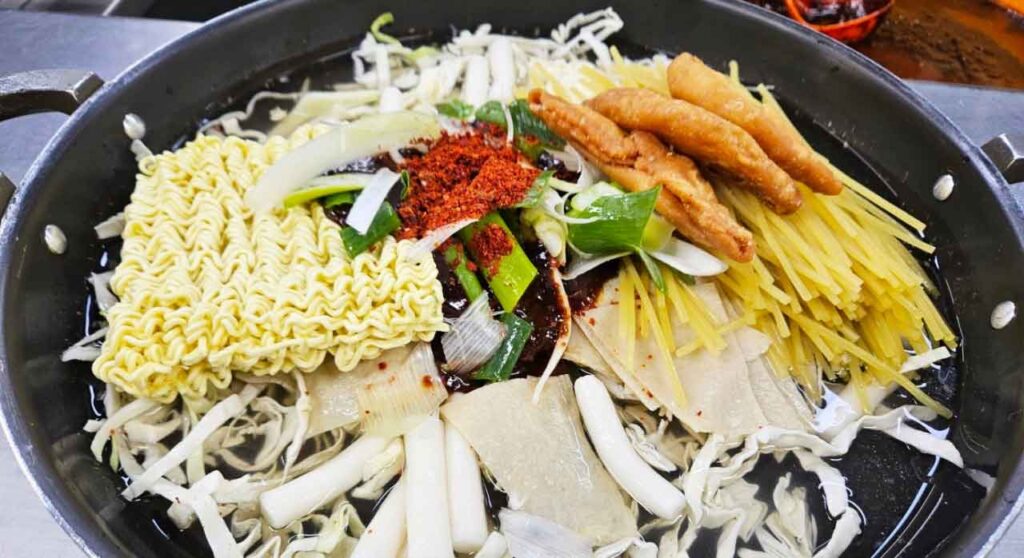 Jeukseok tteokbokki cooking in a pot with noodles and fish cake