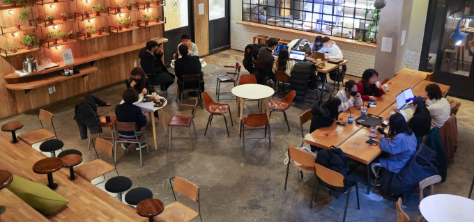 Pessoas conversando, trabalhando ou passando tempo juntas em um café coreano