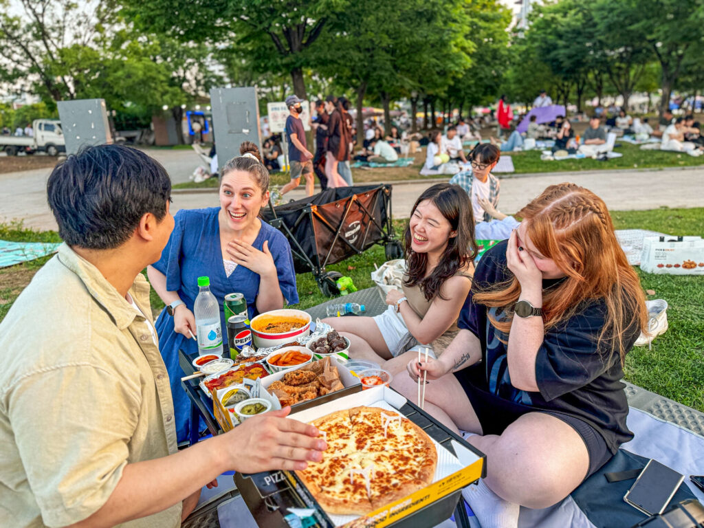 People enjoying delivered food near the Hangang River in Seoul